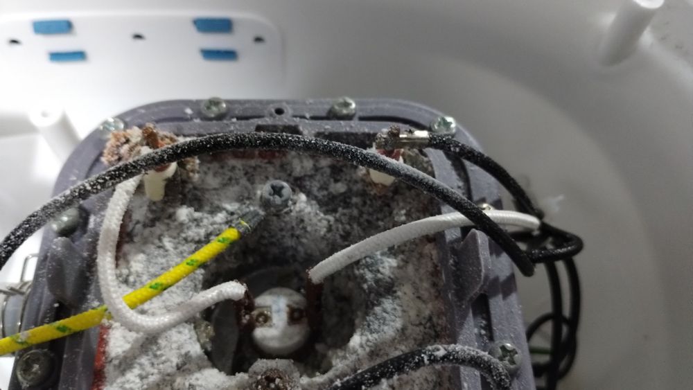 Lower side of the heating element from a garment steamer, the seal shows damage and the metal is rusted and has a calcium buildup