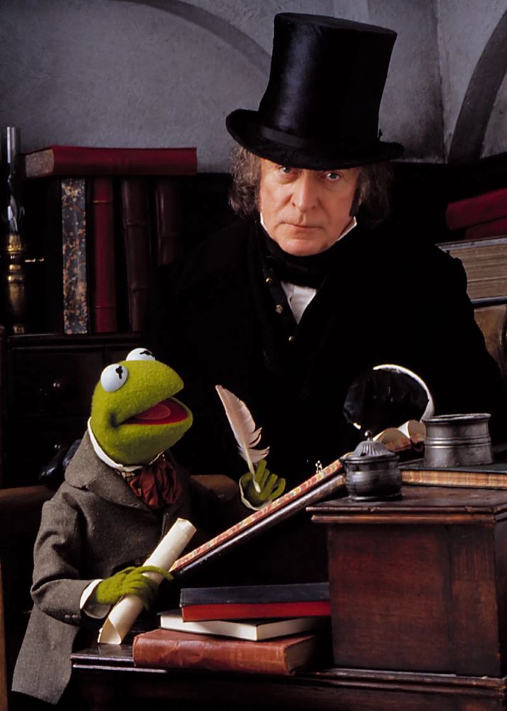 Michael Caine as Ebenezer Scrooge, looming over Kermit the Frog as Bob Cratchit.
