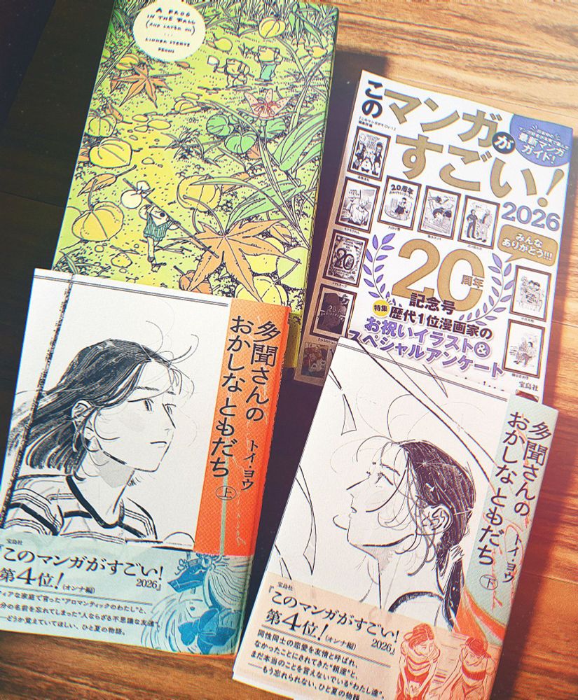 宝島社このマンガがすごい！2026、帯にこの漫画がスゴイ４位と書かれた帯が巻かれている多聞さんのおかしなともだちKADOKAWA上下巻、A Frog in the Fall　Linnea Sterte著がフローリングの床に並んでいる