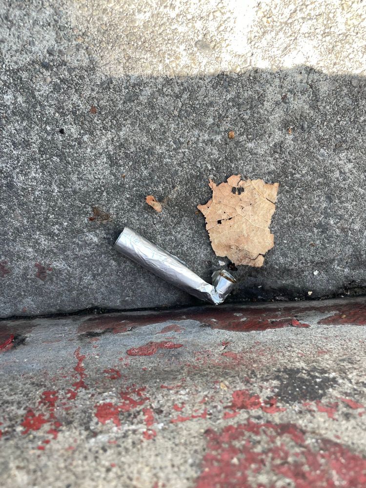 A pipe fashioned out of aluminum foil in a gutter