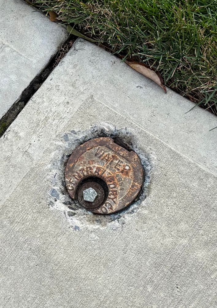Water main cap in a sidewalk 