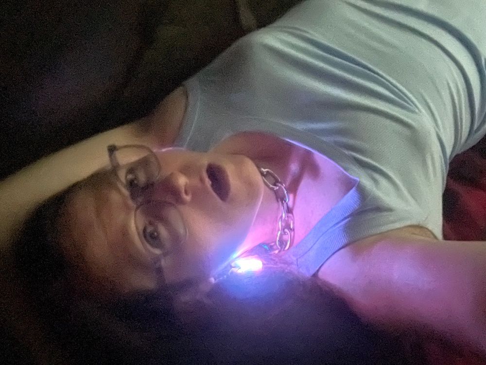A selfie of me wearing my RGB LED earrings laying down in my tent