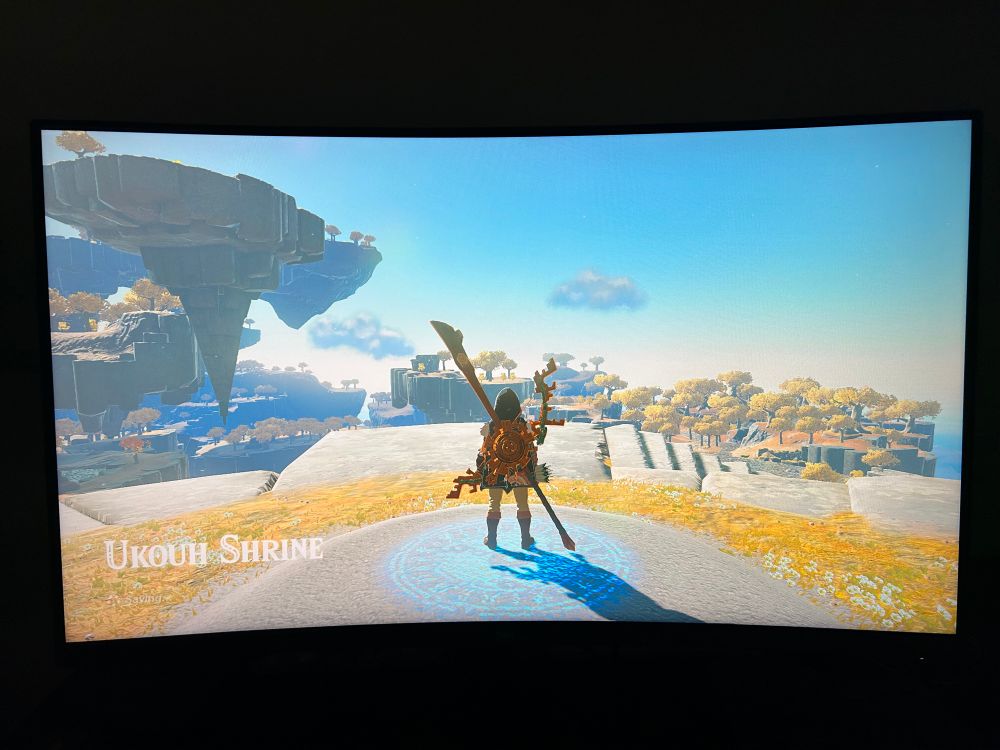 TotK switch 2. Link is standing at the entrance to a shrine on the great sky island. Everything is bathed in a yellow golden glow. 