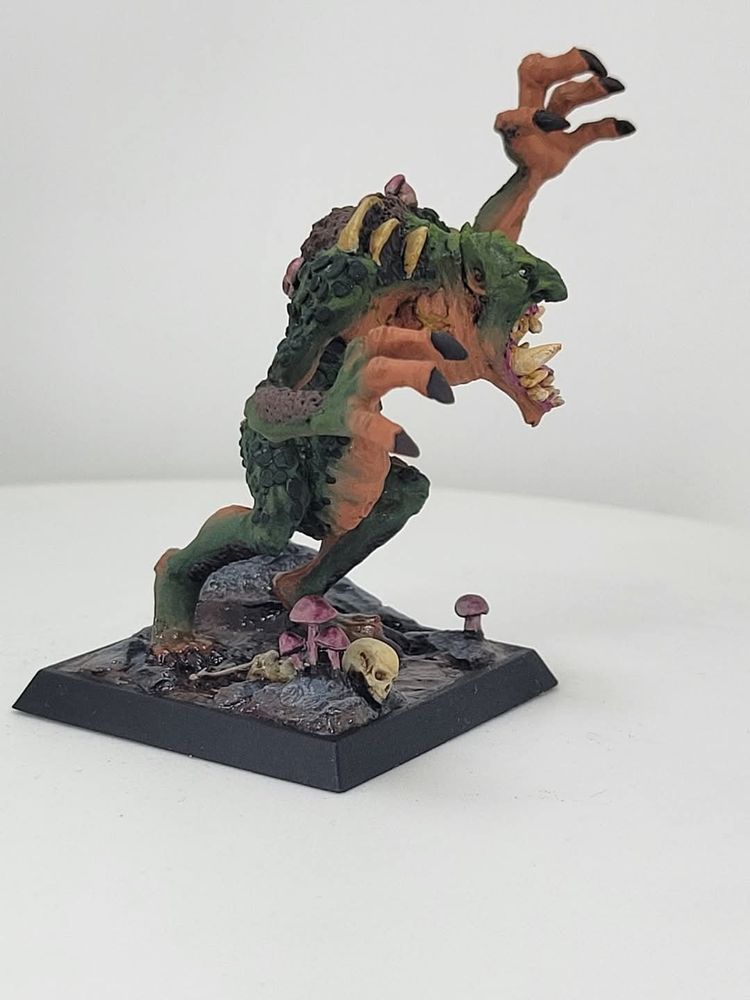 A miniature of a troll in a swamp with mushrooms growing out of it