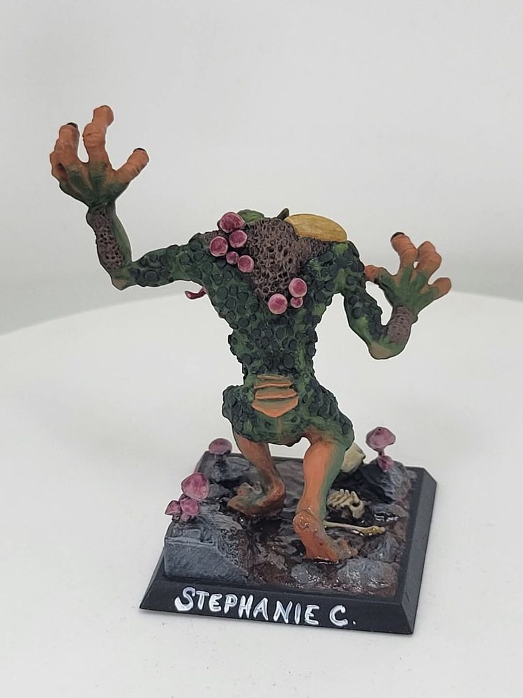 A miniature of a troll in a swamp with mushrooms growing out of it