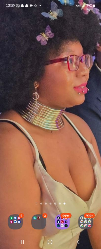 Beautiful black woman wearing an African neck cuff with butterfly clips in her afro.
