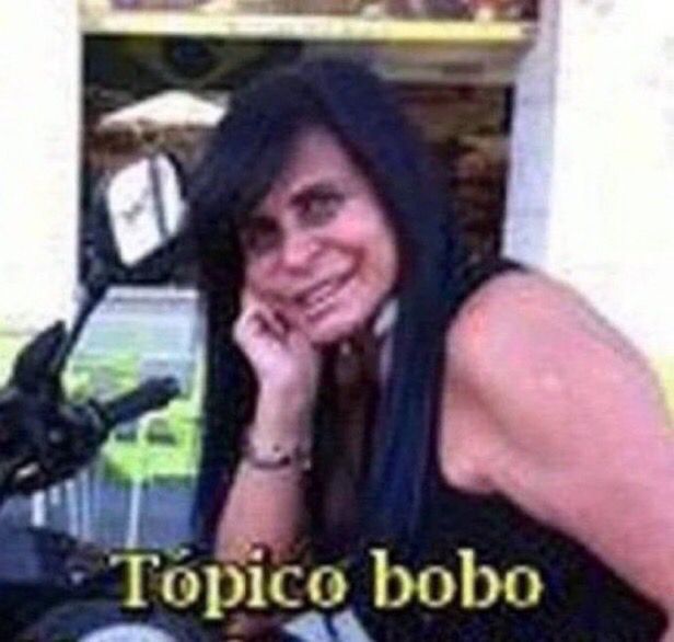 imagem de baixíssima qualidade da gretchen com uma camiseta preta montada em uma moto apoiando seu cotovelo nela enquanto sua mão direita está sob o rosto. a foto tem a legenda “tópico bobo”