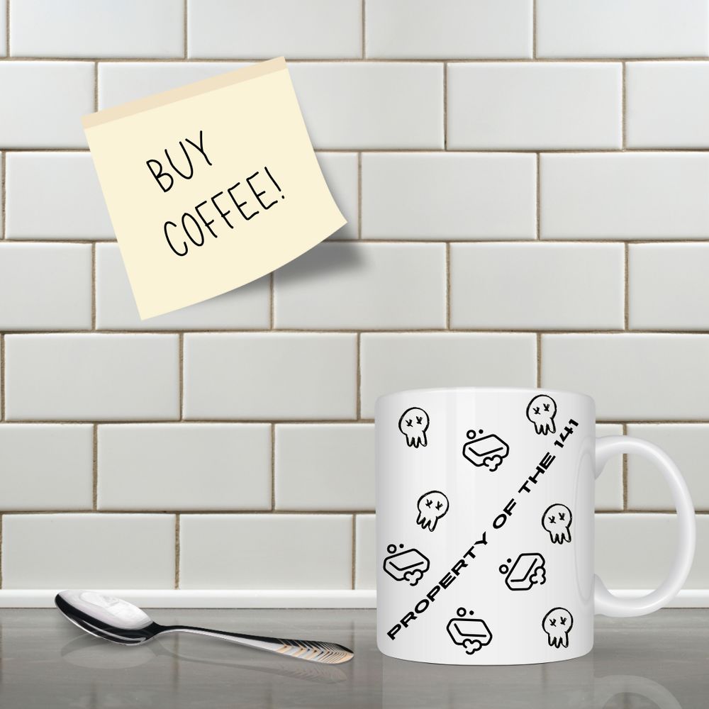 A countertop in a kitchen with a mug and spoon. On the mug, the words "propert of the 141" is printed, alongside tiny soap and skull images. On the wall is a sticky note that reads, "BUY COFFEE!"