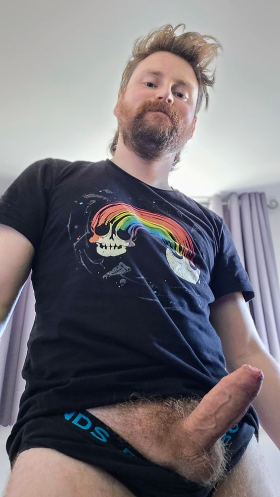 Tiz wearing a pride skull rainbow shirt and black briefs. Hard cock pulled from the the top of the briefs