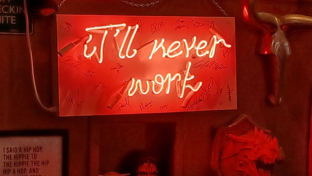 Red neon sign in a wing place in Scotland that says "it'll never work".