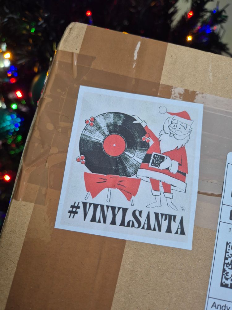 A package showing the #VinylSanta hashtag on a picture featuring the Christmas big man himself, Santa.