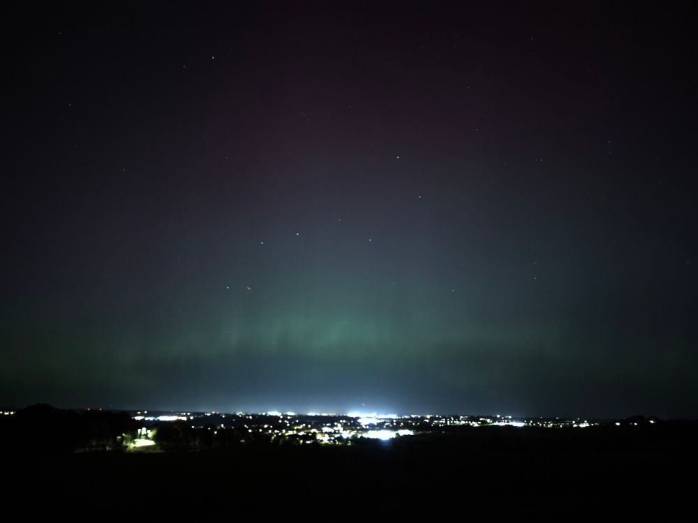 A colourful patch in the middle of the dark night sky. The dotted lights of Spennymoor can be seen along the bottom of the photo.
