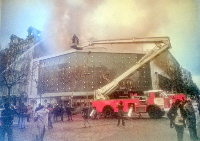 Fotografía de la Sala Scala humeando por el incendio. Se ve gente en la calle y un camión de bomberos.