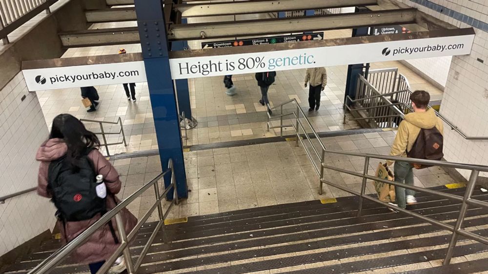an ad in the NY subway for pickyourbaby.com. It reads "Height is 80% genetic"