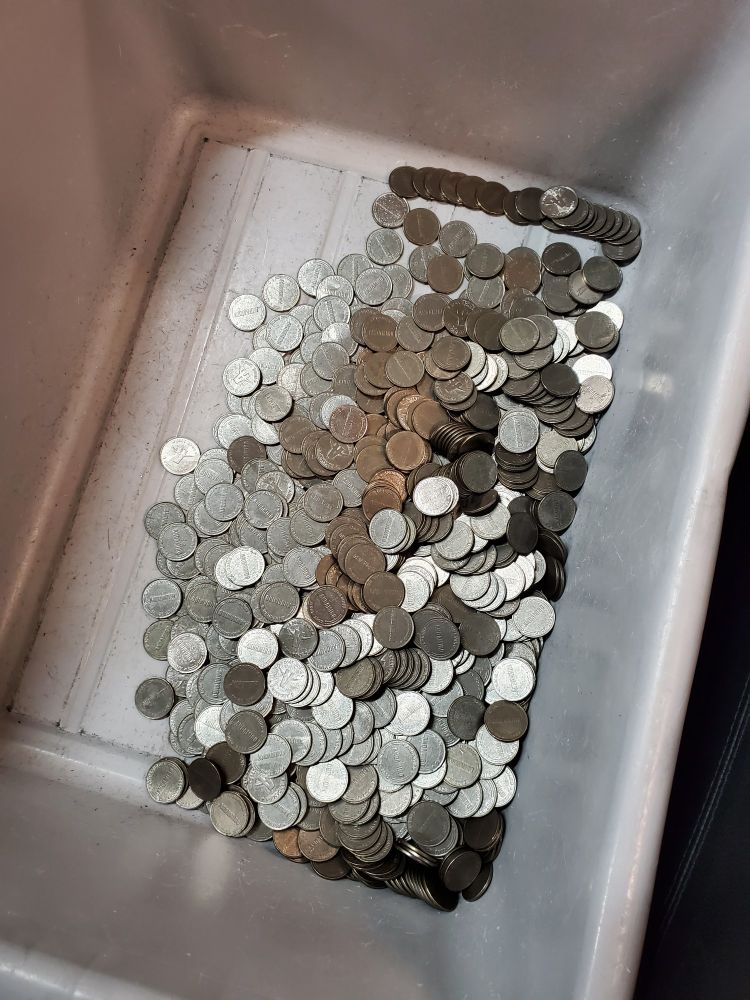 A bin full of noticeably dull tokens that were once shiny