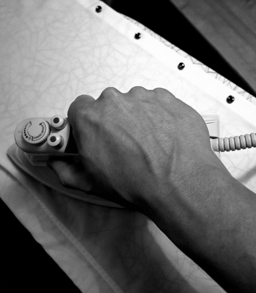 Bügeleisen in der Hand des Accountinhabers, ein Hemd wird gerade gebügelt 