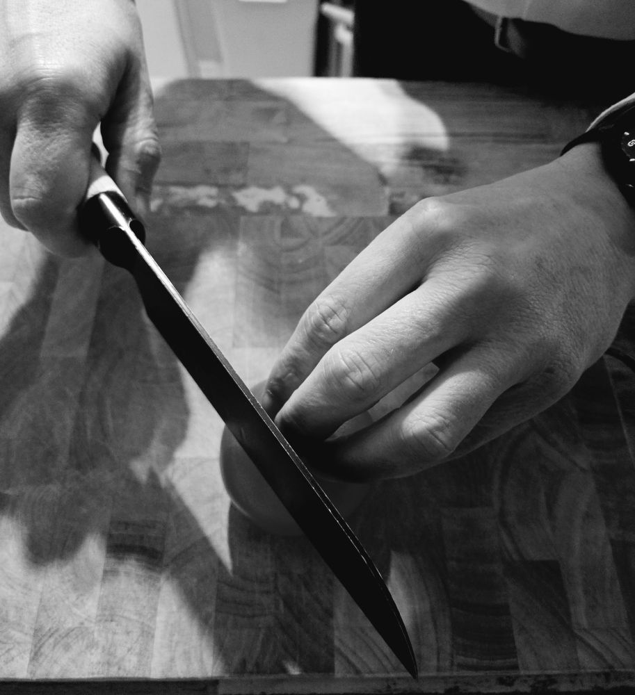 Accountinhaber, der mit einem Messer eine Tomate schneidet 