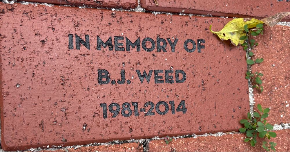 A brick reading “IN MEMORY OF B.J. WEED 1981-2014”