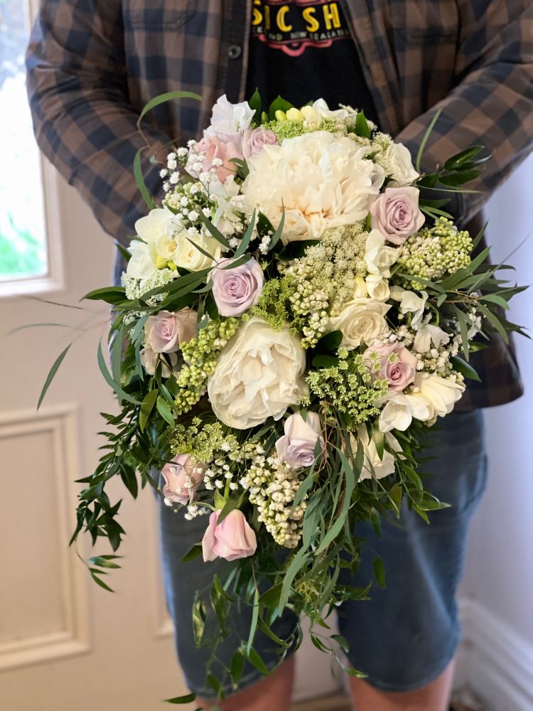 A close up of the bouquet of white Peonies, dusky pink, mauve & white Roses, white Lilac, soft pink Sweetpeas, white Freesias, Queen Anne’s Lace & Baby’s Breath.