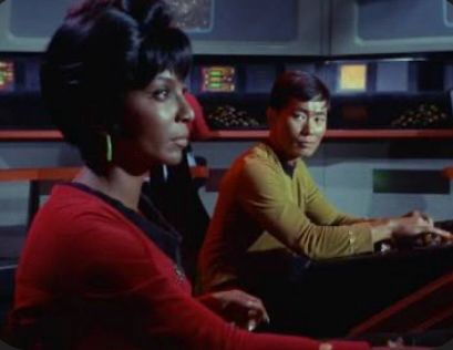 Image from Star Trek TOS “Balance of Terror” Lt. Uhura at navigation station (foreground); Lt. Sulu at helm station (background) and looking toward Lt. Uhura
