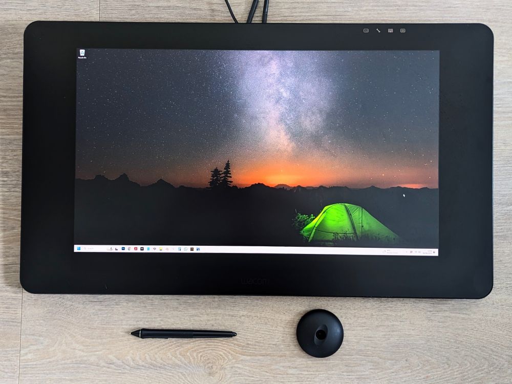 A photo of a Cintiq Pro 24 drawing display, with a Wacom Pro Pen 2 and pen stand. 