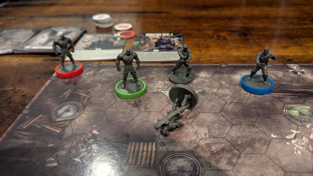 A close up of the board at the end of the game, with four miniatures in play. The "boss" miniature is turned on its side as it has been defeated. 