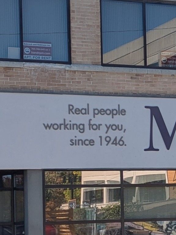 Photo of part of a business's signage which shows their slogan, "Real people working for you, since 1946."