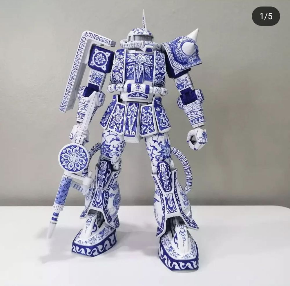 A Zaku Gunpla kit painted to look like white porcelain with blue patterns in a traditional style. 