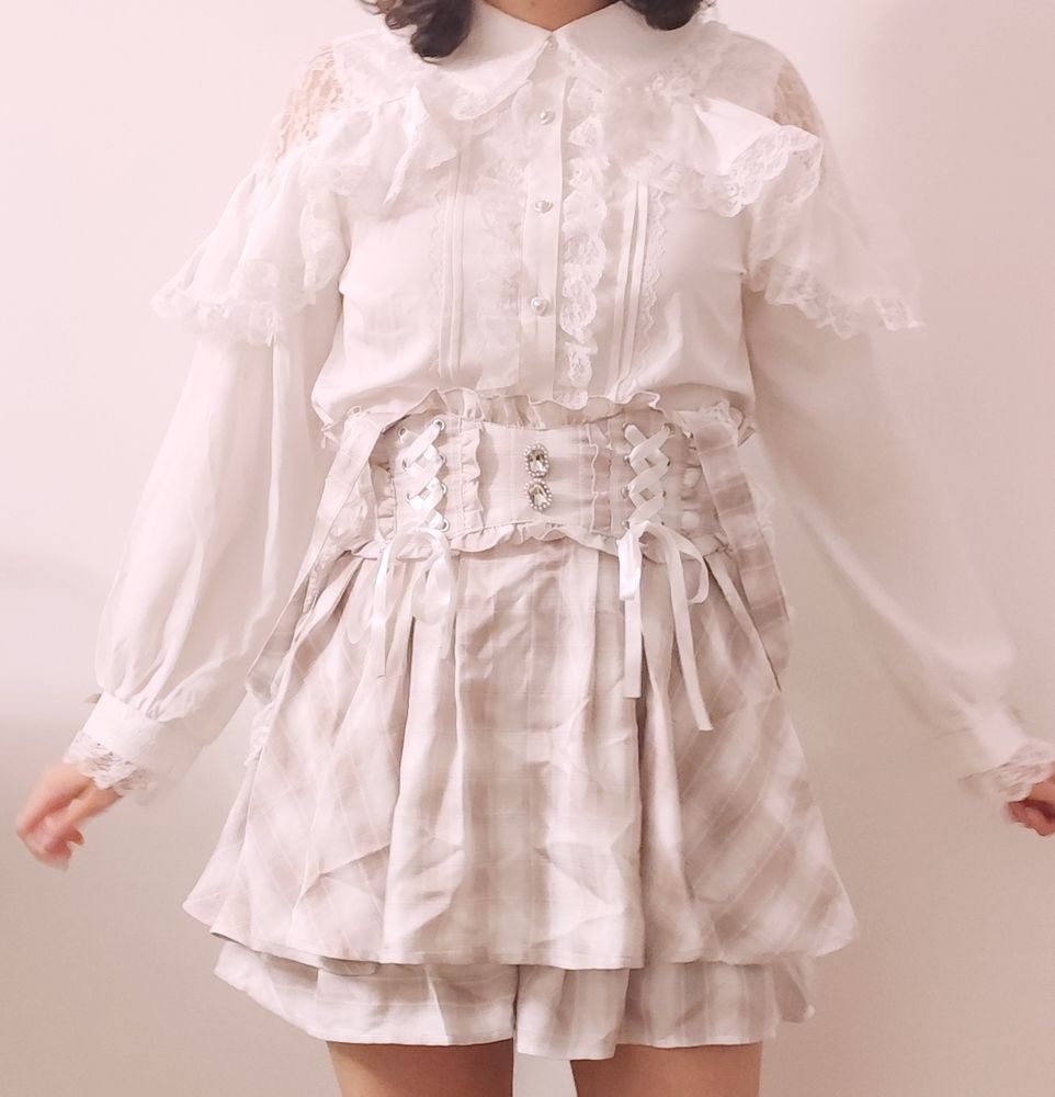 Yo con una falda jirai a cuadros rosa y blanca y una blusa blanca nuclear (???? con volantes y hombros descubiertos pero con encaje