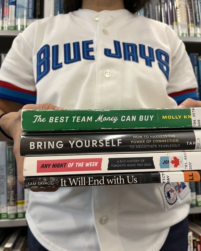 A stack of books with themed titles to cheer on the Blue Jays:
The best team money can buy,
Bring yourself,
Any night of the week,
It will end with us

