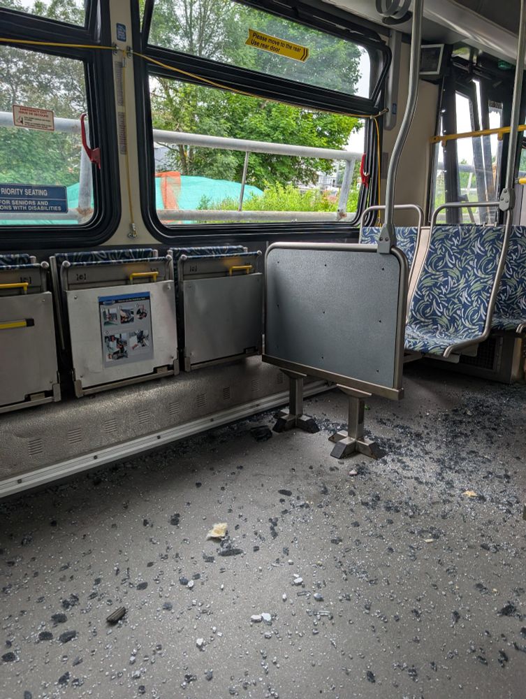 The interior of a Halifax Transit bus with a broken window and glass all over the floor 