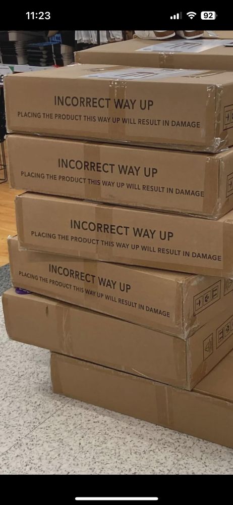 Stack of boxes with message on the edge reading “INCORRECT WAY UP” and “Placing the product this way up will result in damage.”