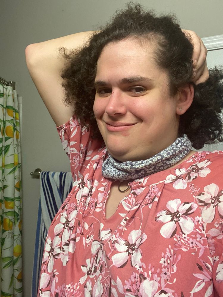 Phoebea body wearing a floral pink top and pushing her hair down so it falls to her neck and overall looking cute as hell