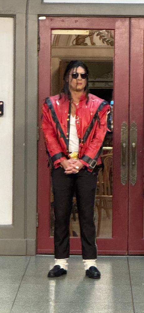 A dancer dressed as Thriller Michael Jackson awaits the cue in front of the Kentucky Theater to lead thousands who have learned the dance and dressed as Zombies down the Main Street of Lexington, Kentucky. Your LFUCG Parks and Rec Culture office for the win. Again. Mecca Dance. Teresa Tomb. 