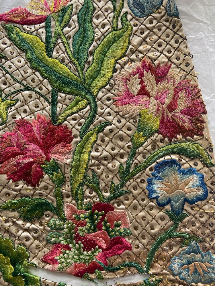 Embroidered waistcoat detail with bright flowers and sequins