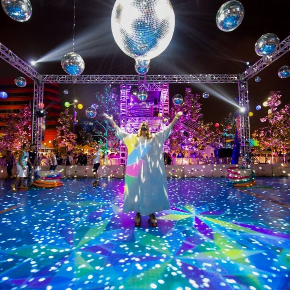Kevin Lee Light, a.k.a. WeHo Jesus at LA Pride in WeHo circa 2013 or 2014. Arms outstretched to the disco balls, beardedface to the heavens, he stands alone on roller skates among a cascade of white and colored lights of the skating rink floor.