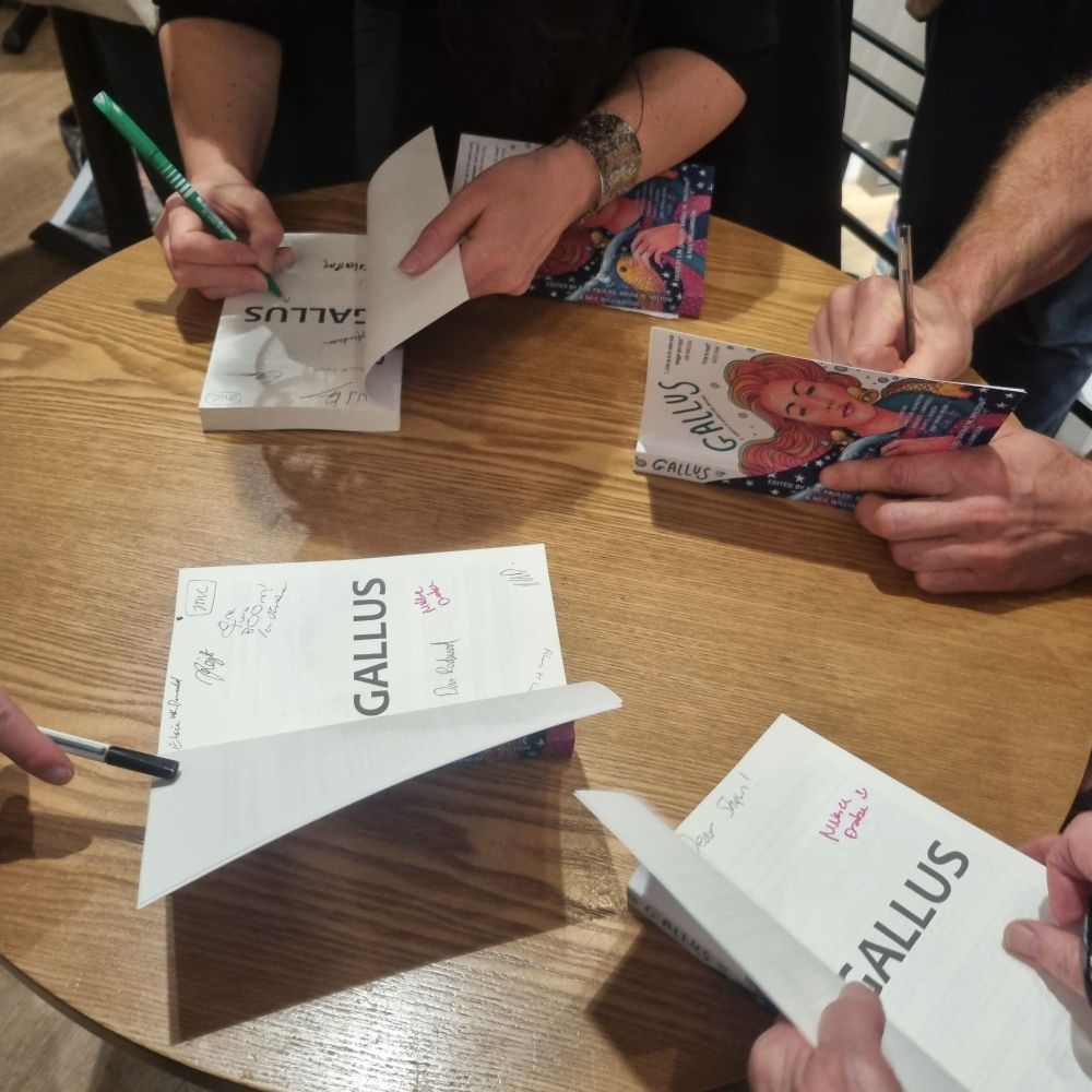 Copies of the book of Gallus being signed by our contributors.