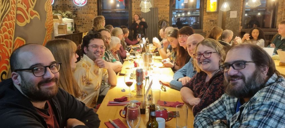 The GSFWC Christmas dinner at Ichiban in Glasgow! A range of mostly white folks sat at a table, ranging genders and aged from 20s to 70s."
