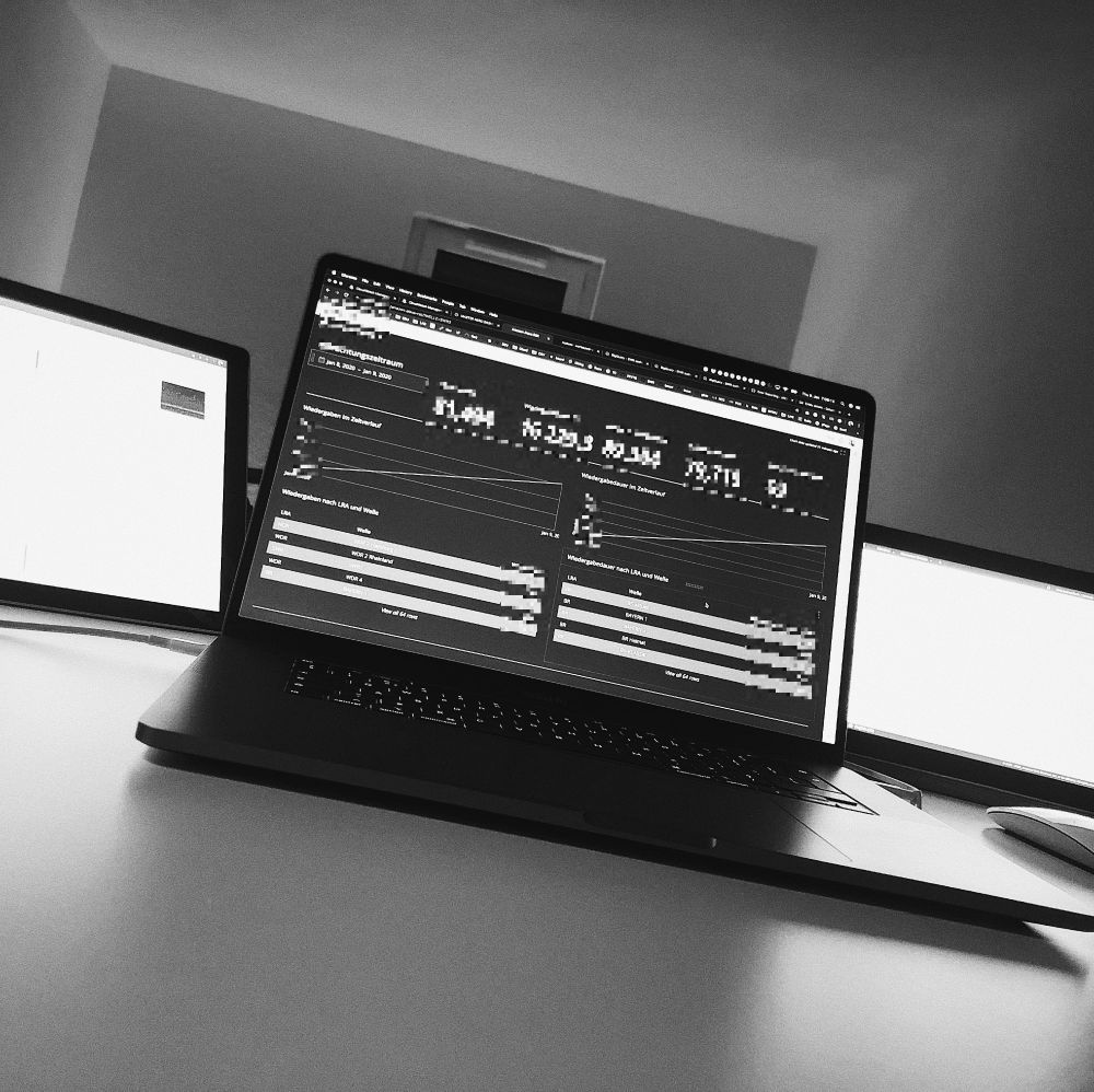 Photo of a DevOps computer setup monitoring several dashboard