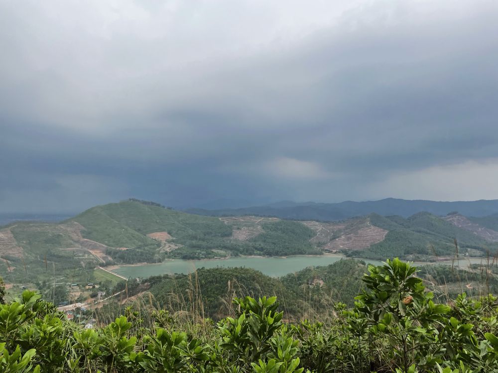 view of a lake from the top of a hike under the stormy cloudy grey sky