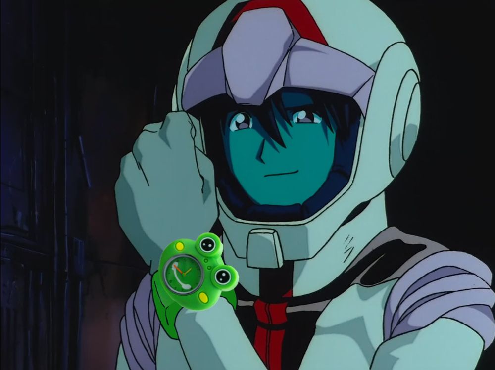 Shiro Amada from Gundam the 08th MS Team wearing his normal suit, smiling, and holding up his arm to show off his watch. It is a green froggy-shaped watch. Very cool, Shiro.