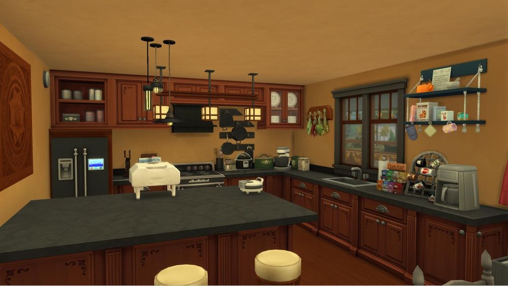 The kitchen of the sims 4 house. The back wall has a row of upper cabinets with 2 cluttered counters below. There is also a fridge and stove on the back wall. The right wall has a two tile wide window above a sink and several cluttered countertops. There is a two tile by three tile kitchen peninsula with 3 stools at it. The kitchen features a mixer, pizza oven, waffle maker, coffee pot, and pressure cooker. The tone of the room is a warm reddish brown.