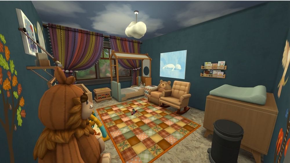 View from the doorway of a blue and nature themed nursery. The walls are blue and the ceiling is painted like a cloudy sky. There is a hanging cloud light in the center of the ceiling. To the right of the door there is a changing table with a trash can. To the left of the door there is a large stuffed animal. On the other side of this of animal , you can see an infant play mat and crib. In the middle of the room there is a quilted rug that is muted red yellow and green. On the back right wall there is a blue painting and a kids bookcases. Next to the bookcase there is a brown rocking chair and a brown bear chair. On the back wall there is a 3 the window with purple, yellow and red striped curtains that are pinned to the side.  Against the backwall there is also a toddler bed with a toy chest next to it.