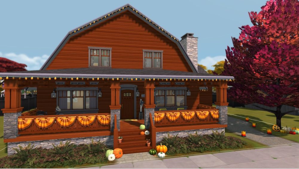 The outside of a sims 4 house build. The house is a warm redish brown color. There are orange and yellow banners and lights on the house, as well as pumpkins out front and on the steps to help decorate for fall. There is a big tree on the right that has red and orange leaves. Next to the tree there is a path leading to the backyard. 