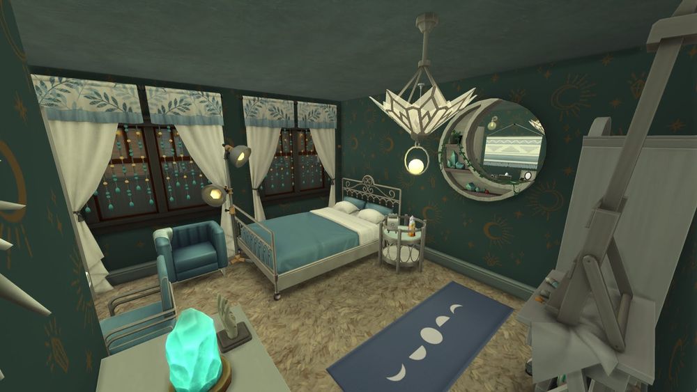 View from the doorway of the blue and crystal themed bedroom I designed for a teenager or adult in the house. Plush beige carpet with celestial blue walls. The bed in the back corner is silver and blue with a silver and mirrored side table. There is a circular moon mirror on the wall with a blue moon themed yoga may in front of it. There is an easel to the right of the door with a crystal display next to is. To the left of the door is a wall with a white dresser on it. By the base of the bed there is a blue chair with a lamp next to it. 