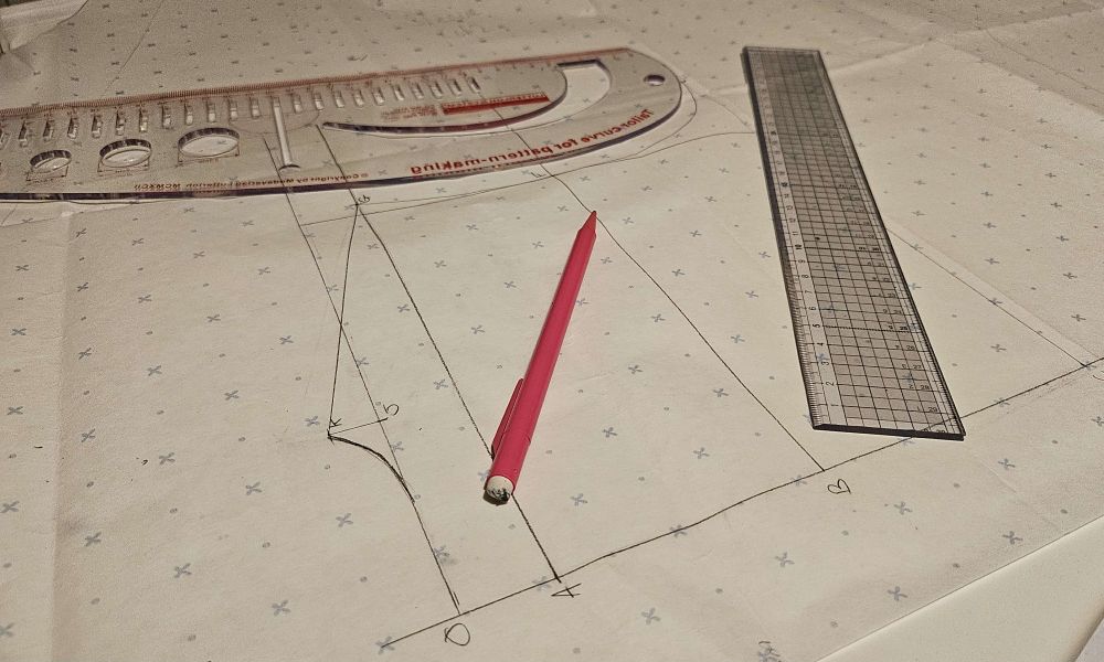 A piece of pattern drafting with a ruler, pencil and curved rule