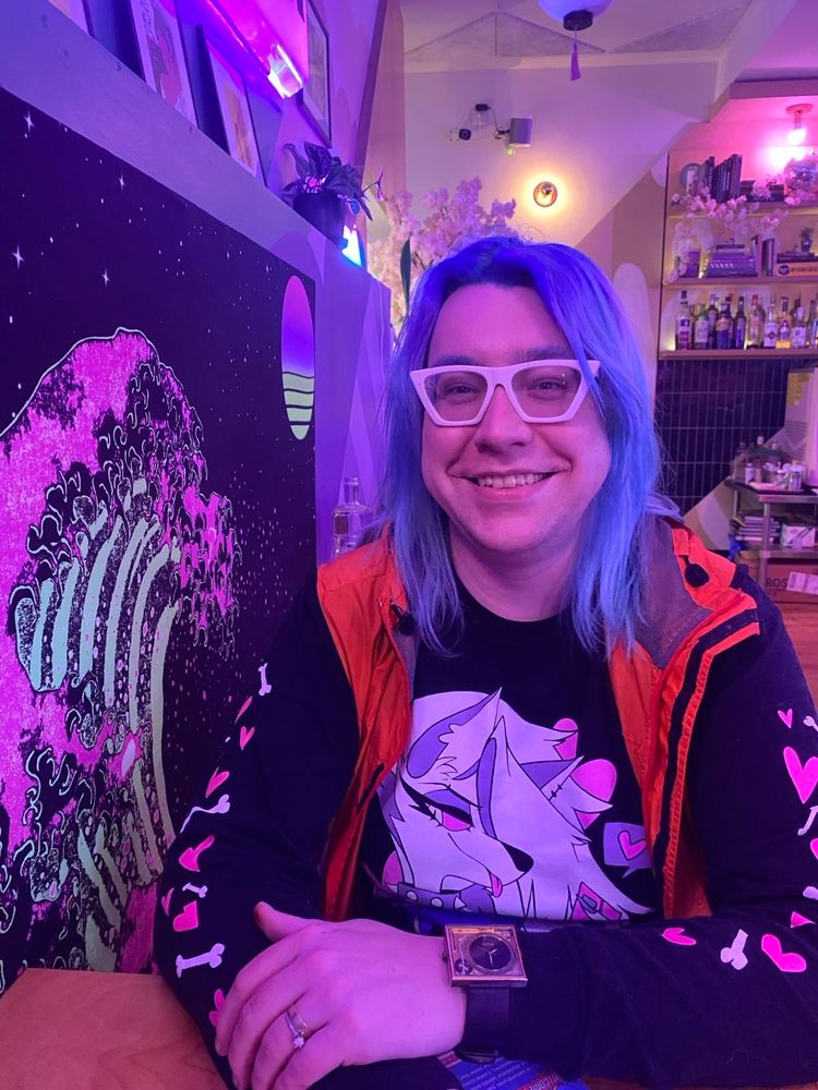 Me smiling @lawbird bar next to. Neon rendition of Hokusai's "The Great Wave off Kanegawa"