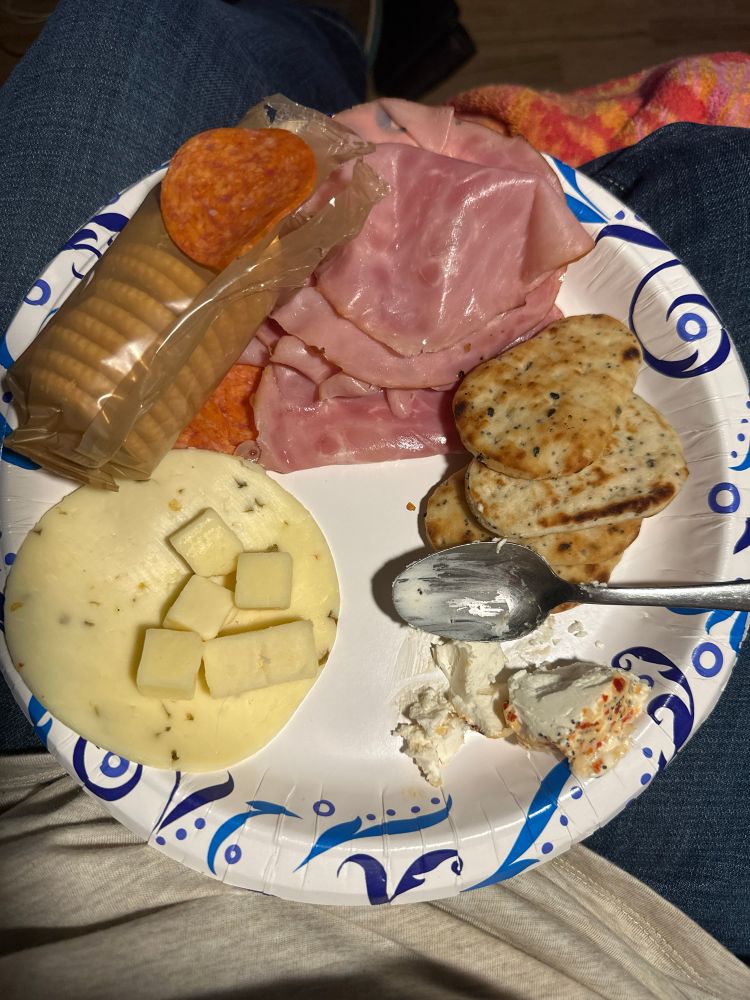 Plate of food featuring ham, pepperoni, crackers, naan, and cheese 