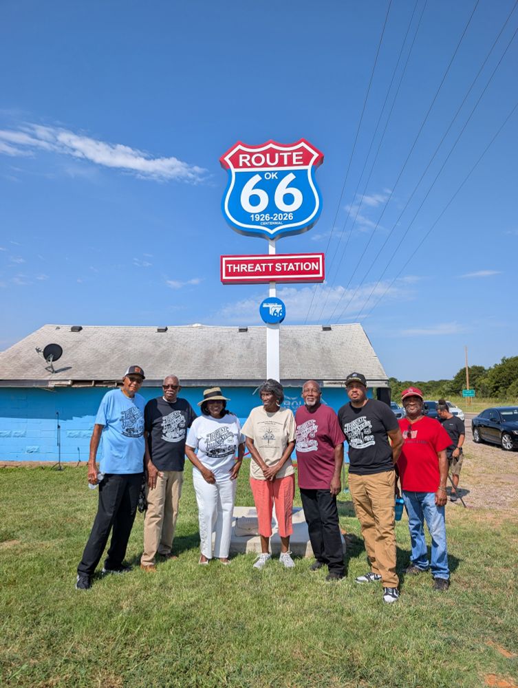 Members of the Threatt Family of Luther, Oklahoma stand underneath a new Route 66 landmark sign. 