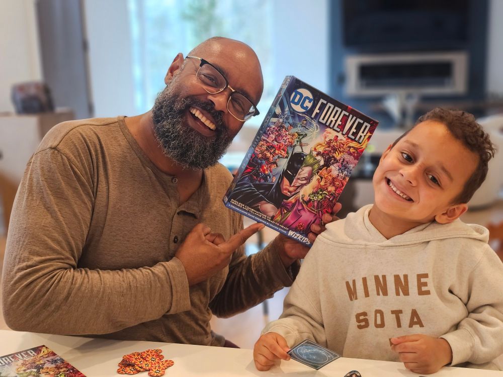 Designer Damon Stone poses with his newest tabletop game, DC Forever. 